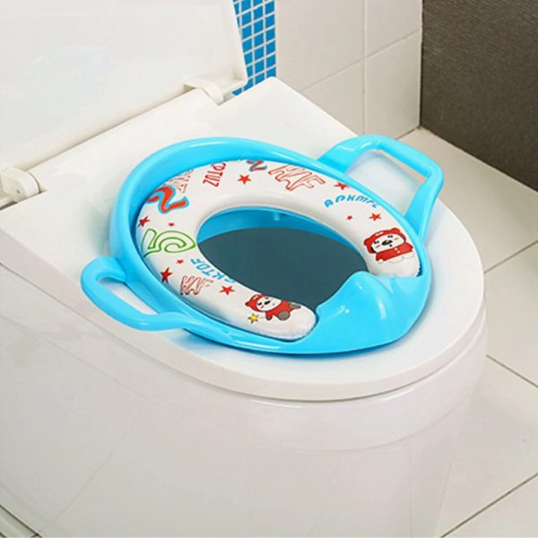 Toddler smiling and confident while using a soft potty training seat.