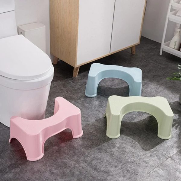 Child smiling and using the toilet comfortably with a colorful Squatty Potty stool.