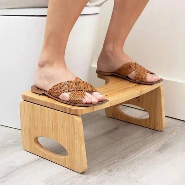 Elderly woman sitting comfortably on a folding toilet stool in the bathroom.