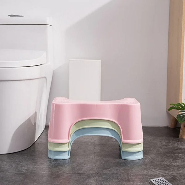 Parent smiling and assisting a young child using the Squatty Potty stool