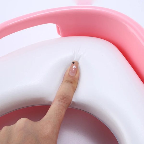 Close-up view of a disposable toilet seat cover on a toilet seat, emphasizing how it creates a protective barrier.